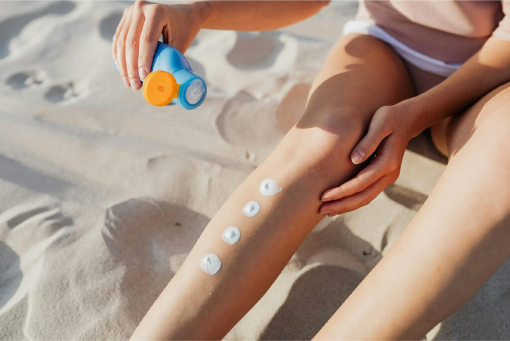 a person applying sunscreen on a leg